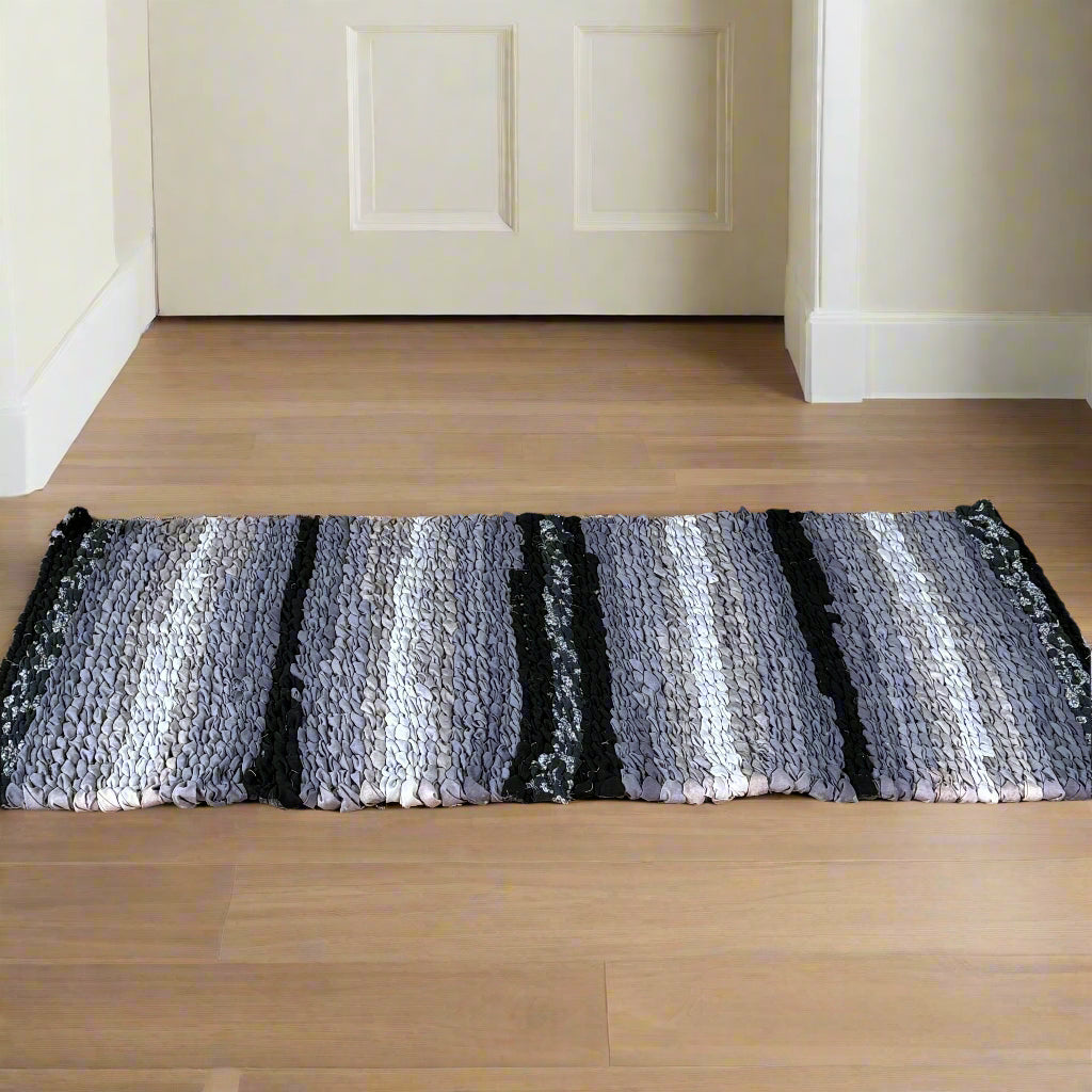 Wooden cabinet with decorative items and a striped rug on a wooden floor.