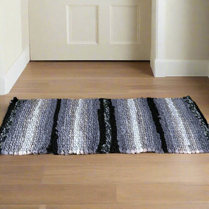 Wooden cabinet with decorative items and a striped rug on a wooden floor.